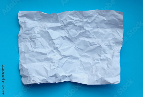 Crumpled paper isolated on blue background .