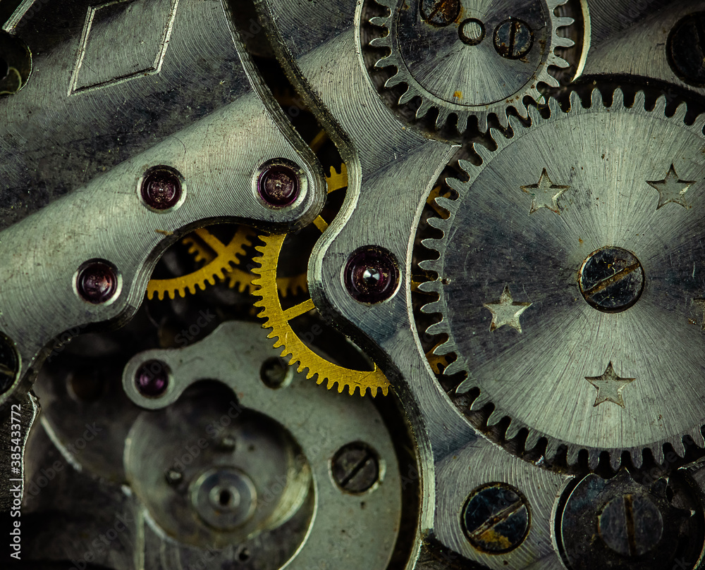 Vintage watch movement close - up. Selective focus on elements, macro photography. Background in steampunk style. Metallic grunge texture. Easy image tinting