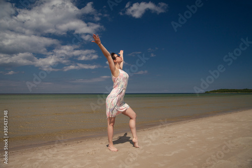 young happy girl in summer dress by the sea