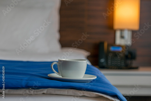 Cup of coffee on hotel bed
