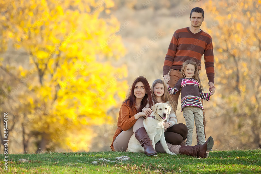 Fototapeta premium Family resting in nature in autumn. Beautiful woman with a man have fun playing with children. High quality photo.