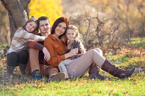 Family resting in nature in autumn. Beautiful woman with a man have fun playing with children. High quality photo.