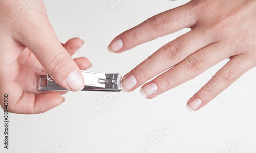 Girl cutting fingernails using a nail clipper.