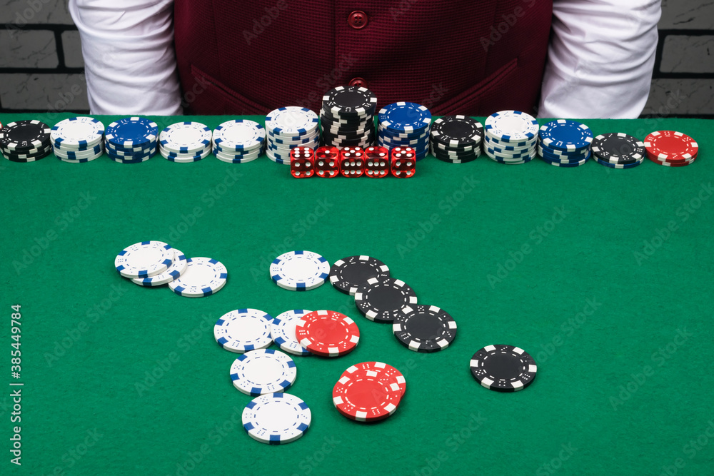 different bets and chips on the green poker table in front of the dealer different bets and chips on the green poker table in front of the dealer