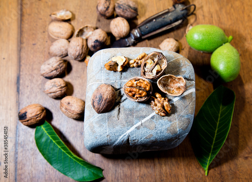 shelled walnuts with old peasant knife on gray stone with around dried and fresh walnuts food