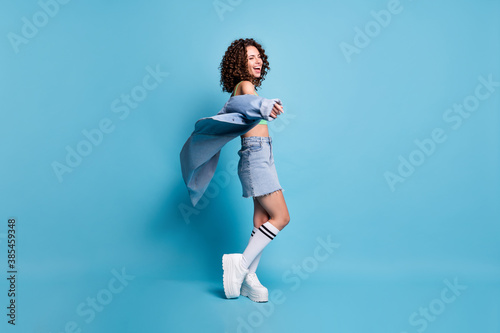 Full size profile photo crazy cheerful festive lady model laugh jacket air entertainment center advert wear green top jeans shirt skirt platform shoes isolated pastel blue color background