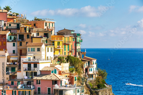 Manarola, Cinque Terre in Liguria in Italy. Aerial view of colorful houses and the blue sea in the background. Coastline landscape. © angelocordeschi