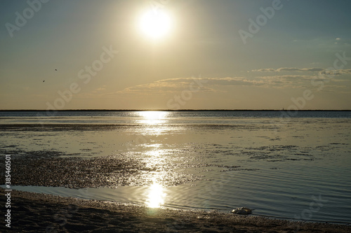 A sunny path from the setting sun on the calm water of the estuary. photo