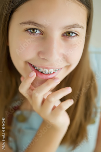 Close up portrait of smiling teenager girl showing dental braces.Isolated on white background. High quality photo.