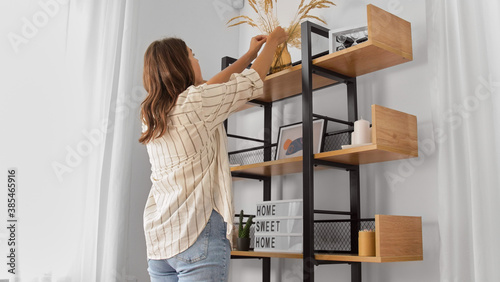 Quadro em tela home improvement, decoration and people concept - woman placing dried flowers or