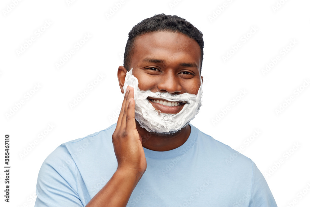 grooming and people concept - african american young man with shaving cream on his beard over white background