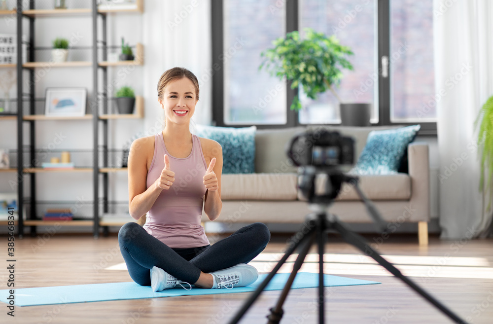 fitness, sport and video blogging concept - woman or blogger with camera on tripod recording online training class at home fitness, sport and video blogging concept - woman or blogger with camera on tripod recording online training class at home