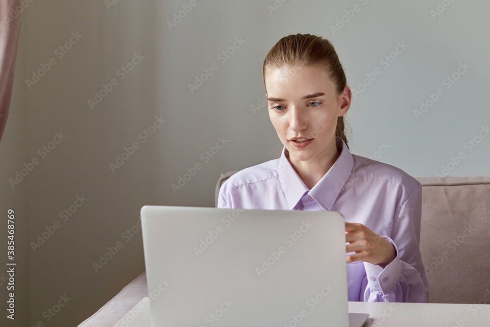 Beautiful young woman sitting at home talking via video link online. Beautiful face with natural makeup. Beautiful young woman sitting at home talking via video link online. Beautiful face with natural makeup.