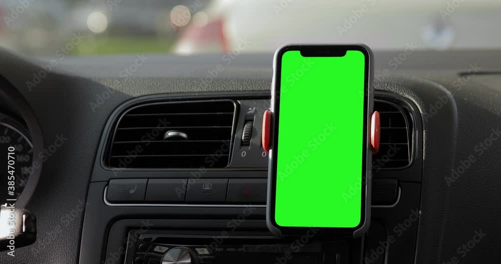 Close up shot of the iPhone 11 Pro Max placed on the car dashboard. A device with a keyed green screen. Autumn fall street, traffic jam. Blank mock-up screen.
