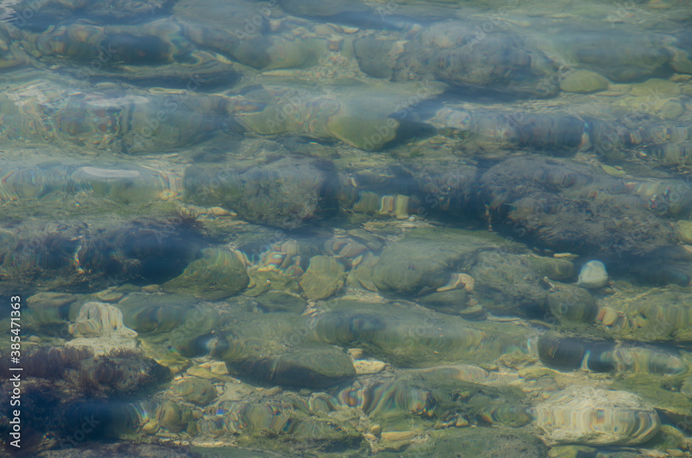 Sea floor with pebbles underwater. Pure water.