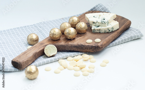 chocolate truffles made from white chocolate and dor blue cheese on a wooden board
