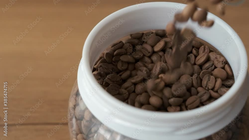 roasted coffee beans pouring into the container in slow motion roasted coffee beans pouring into the container in slow motion