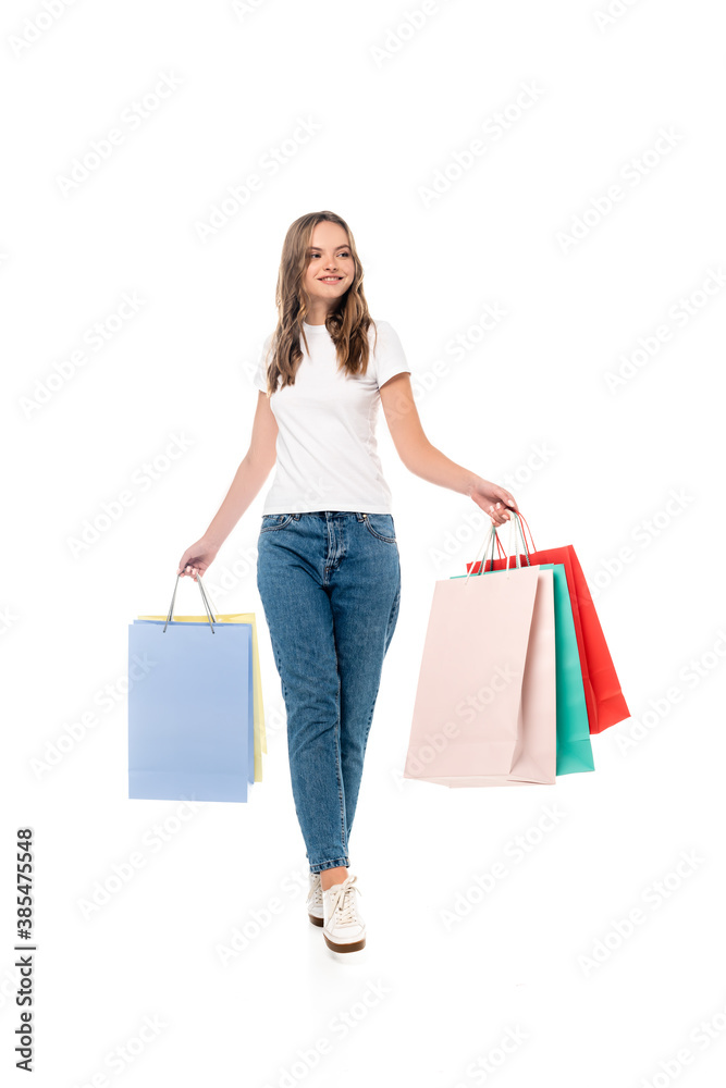 young joyful woman holding shopping bags isolated on white