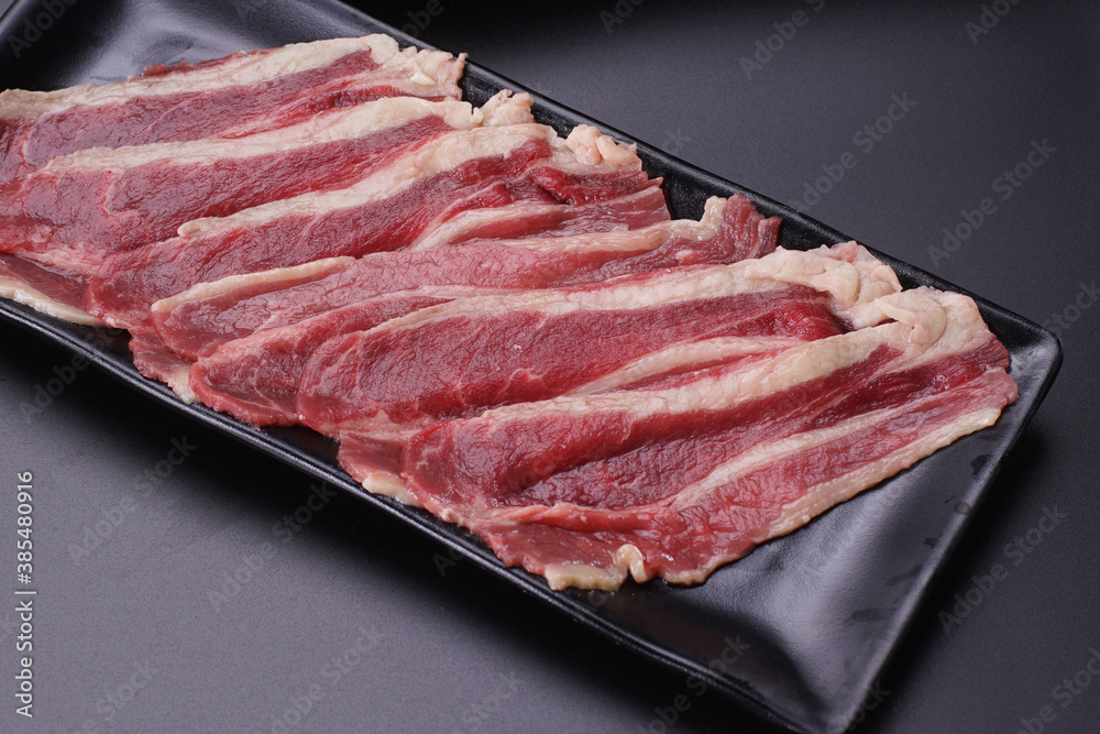 Raw beef slice for barbecue japanese style, yakiniku, meat are being cooked on stove. Raw beef slice for barbecue japanese style, yakiniku, meat are being cooked on stove.