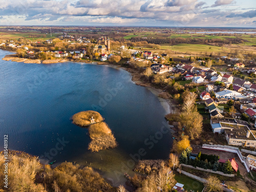 Aerial view of Rajgrodzkie Lake, small chapel on the island and church in Rajgrod, autumn time, Poland