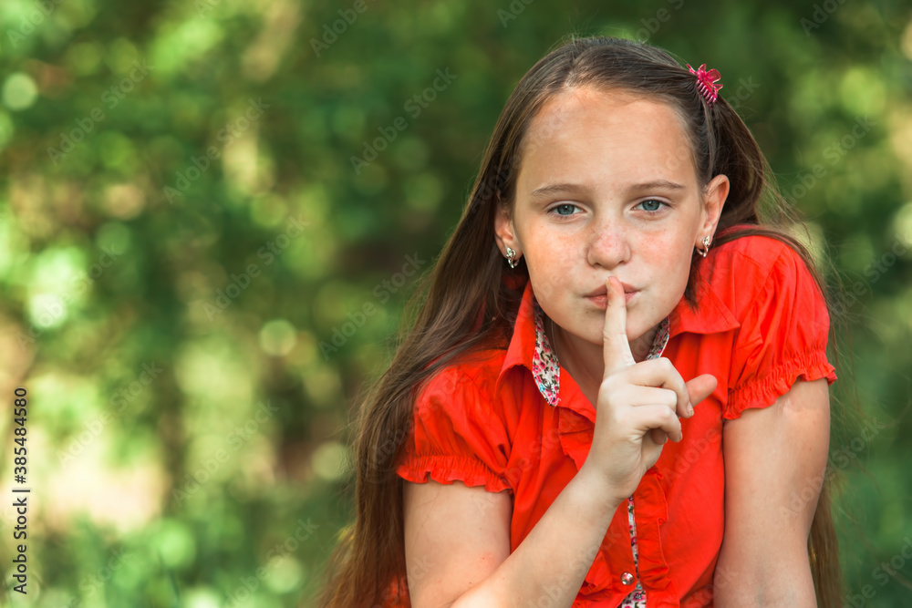 Hushing. Teen girl with her finger over her mouth. Hushing. Teen girl with her finger over her mouth.