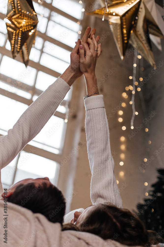 the intertwining of hands of a couple in love on the background of christmas lights the intertwining of hands of a couple in love on the background of christmas lights
