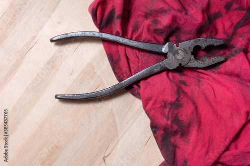 Bilde på lerret Pliers on a red oiled rag