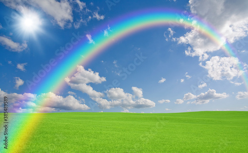 緑の草原と雲と虹と太陽