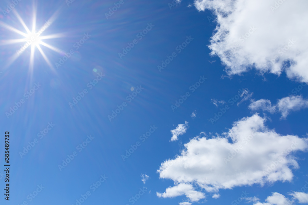 The rays of the sun on blue sky with cumulus clouds