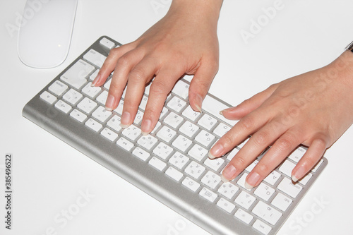 パソコンのキーボード打つ女性の手