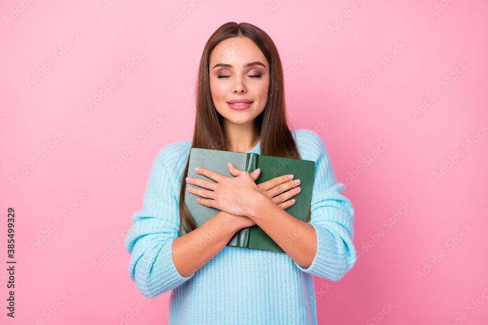 Photo of attractive lady hold book hands close to chest fond of reading spend free time hobby eyes closed dreamer wear knitted blue pullover isolated pastel pink color background Photo of attractive lady hold book hands close to chest fond of reading spend free time hobby eyes closed dreamer wear knitted blue pullover isolated pastel pink color background