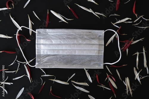 Medical mask with white flowers and red leaves. Place under the text. The concept of spring and summer in the context of the Covid-19 pandemic. Allergy concept. 