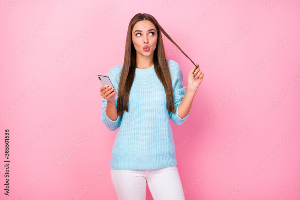 Photo of pretty blogger lady hold telephone look empty space write post wound curl on finger send air kiss wear knitted blue sweater white trousers isolated pastel pink color background Photo of pretty blogger lady hold telephone look empty space write post wound curl on finger send air kiss wear knitted blue sweater white trousers isolated pastel pink color background