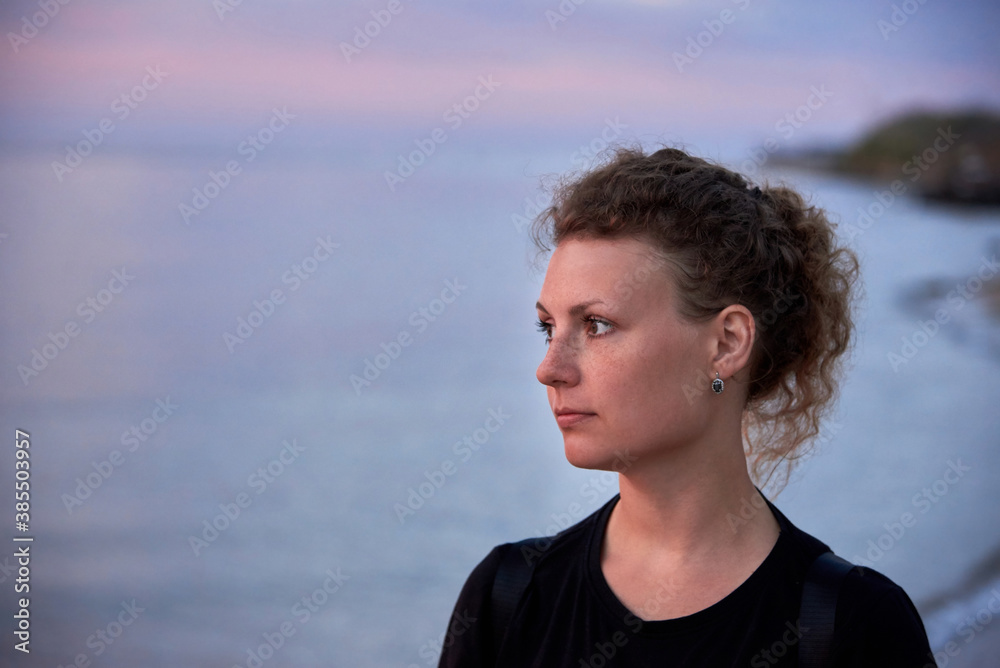 Portrait of a pretty beautiful woman against the background of the sea. Portrait of a pretty beautiful woman against the background of the sea.