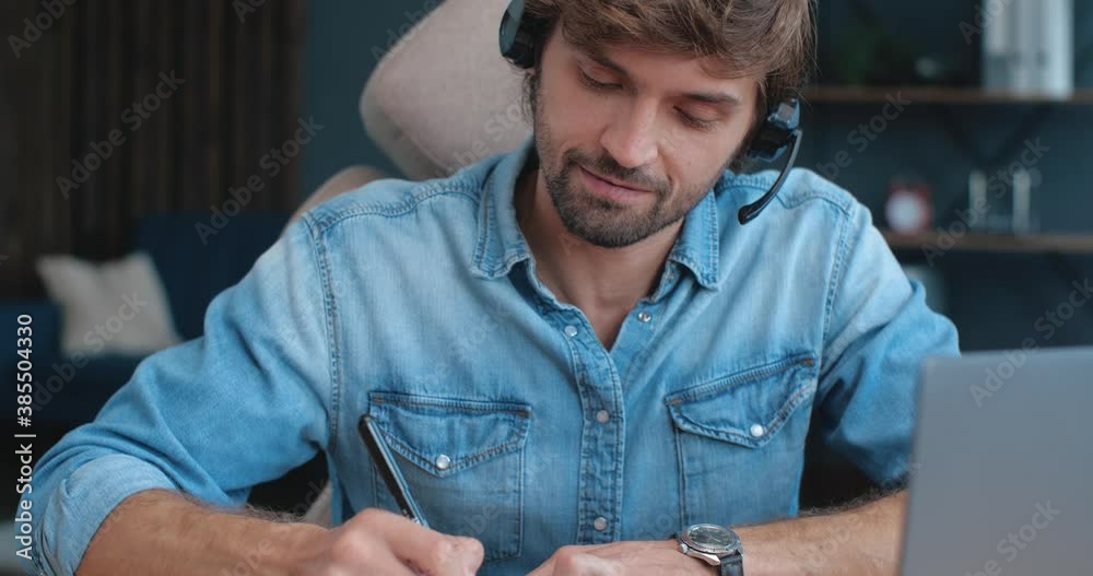 Close Up of young Caucasian Student in Headset is studying from Home on Laptop. Cute Caucasian Guy Man is holding Online Translation, Video Call at Home Office. Class, distantly Education, Lessons. Close Up of young Caucasian Student in Headset is studying from Home on Laptop. Cute Caucasian Guy Man is holding Online Translation, Video Call at Home Office. Class, distantly Education, Lessons.