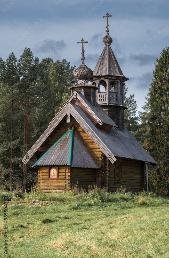 Small wooden ancient orthodox  church with a dome and a cross in the Russian village