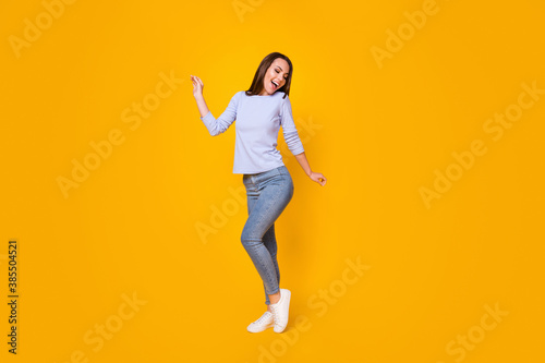 Full length body size view of her she attractive pretty lovely cheerful cheery girl having fun dancing good mood weekend pastime isolated bright vivid shine vibrant yellow color background © deagreez