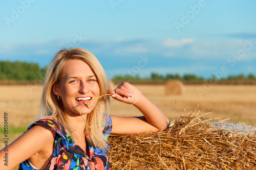 Beautiful woman posing on a wheat bale