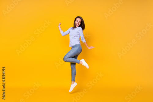 Full length body size view of her she attractive pretty lovely cheerful cheery girl jumping having fun good mood healthy comfort life isolated bright vivid shine vibrant yellow color background