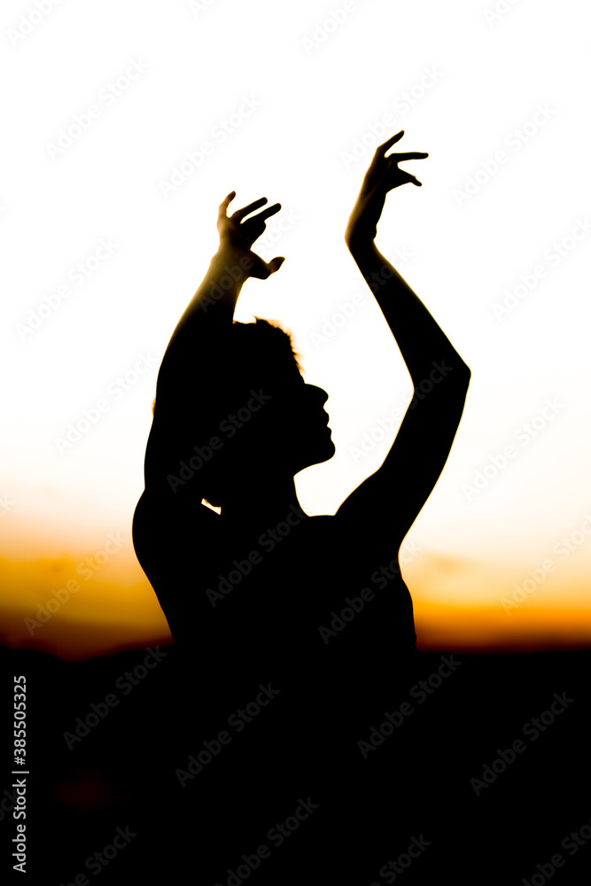 silhouette of a woman, girl dancing at sunset