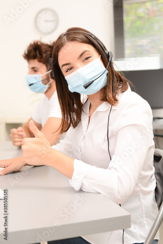 group of young people telephone operator with headset working in office medical helpline service call center support business with a surgical mask protection