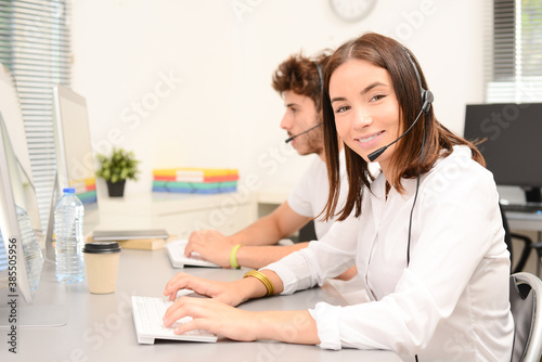 group of young people telephone operator with headset working on desktop computer in a row in customer service call support helpline business center