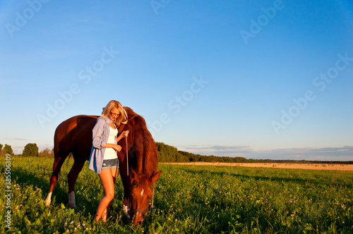 Young girl walking with a horse in the field © Yury