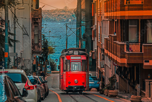Old nostalgic tram going through the streets of Kadikoy district on the Asian side of Istanbul. The trendy neighborhood is full of colorful buildings. Marmara Sea. photo
