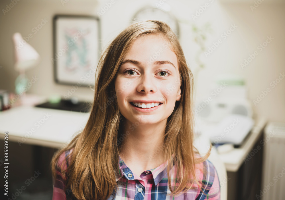 Portrait of blond long haired happy smiling caucasian teenage girl in her room Portrait of blond long haired happy smiling caucasian teenage girl in her room