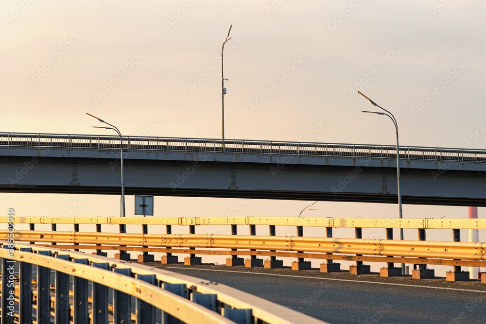 Abstract photo of traffic intersection. Metal construction of road bridge against blue sky. The New Darnytskyi Bridge is a combined road and railroad bridge in Kyiv over Dnipro River. Ukraine Abstract photo of traffic intersection. Metal construction of road bridge against blue sky. The New Darnytskyi Bridge is a combined road and railroad bridge in Kyiv over Dnipro River. Ukraine