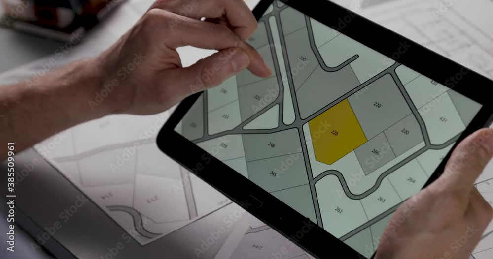 choosing building plot for sale on cadastral plan for house construction on digital tablet. slider shot