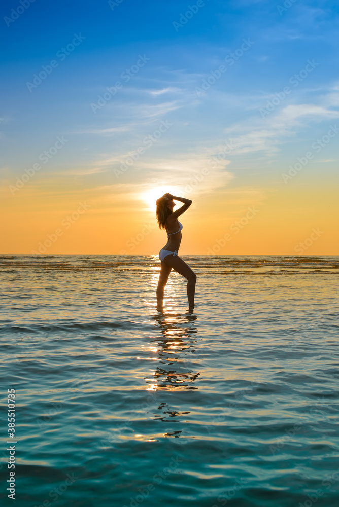 woman in white bikini posing in a sea