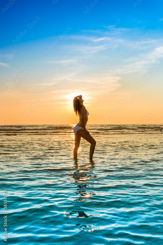woman in white bikini posing in a sea
