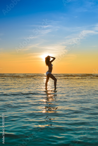 woman in white bikini posing in a sea © Yury